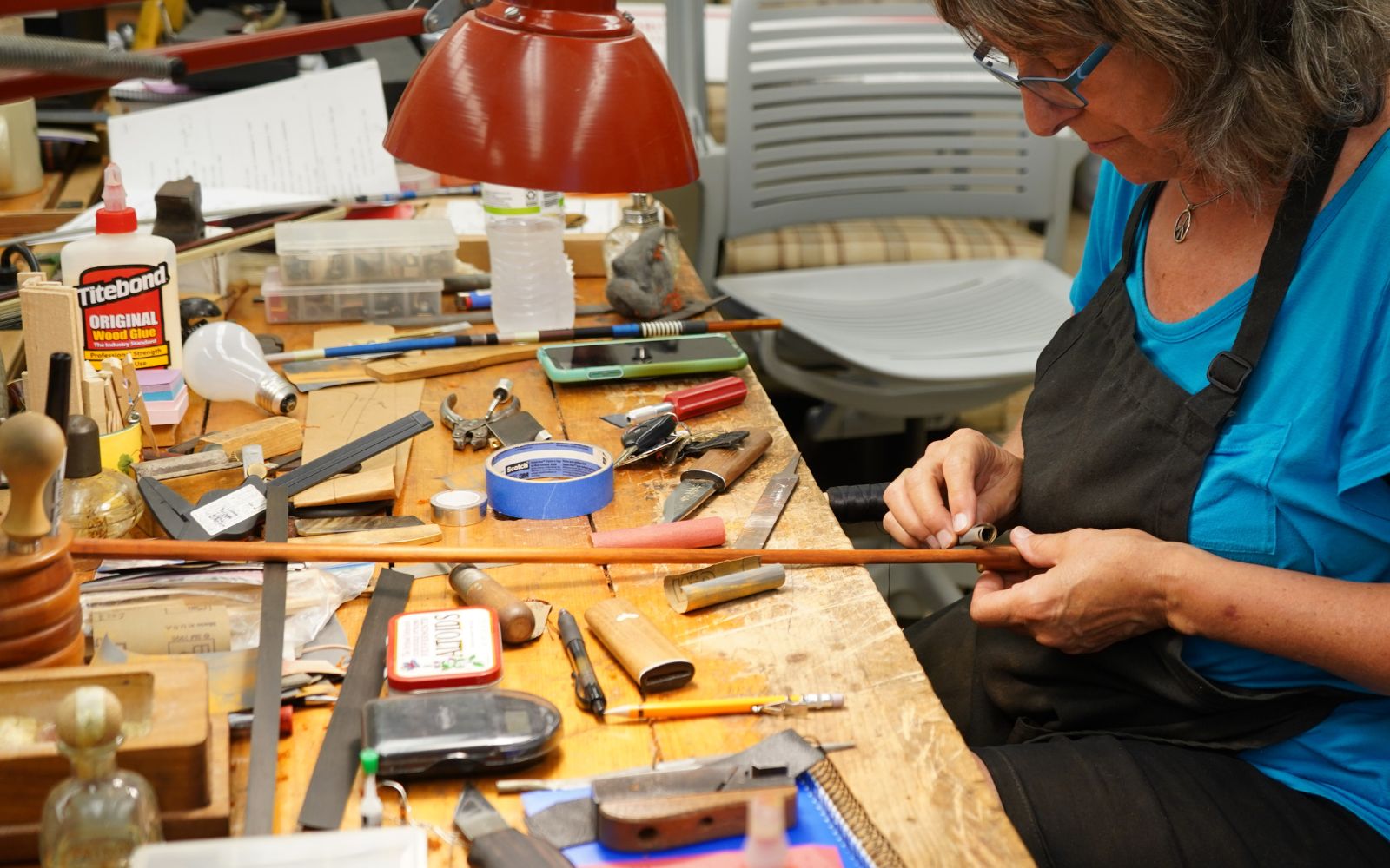 Instructor repairing violin bow
