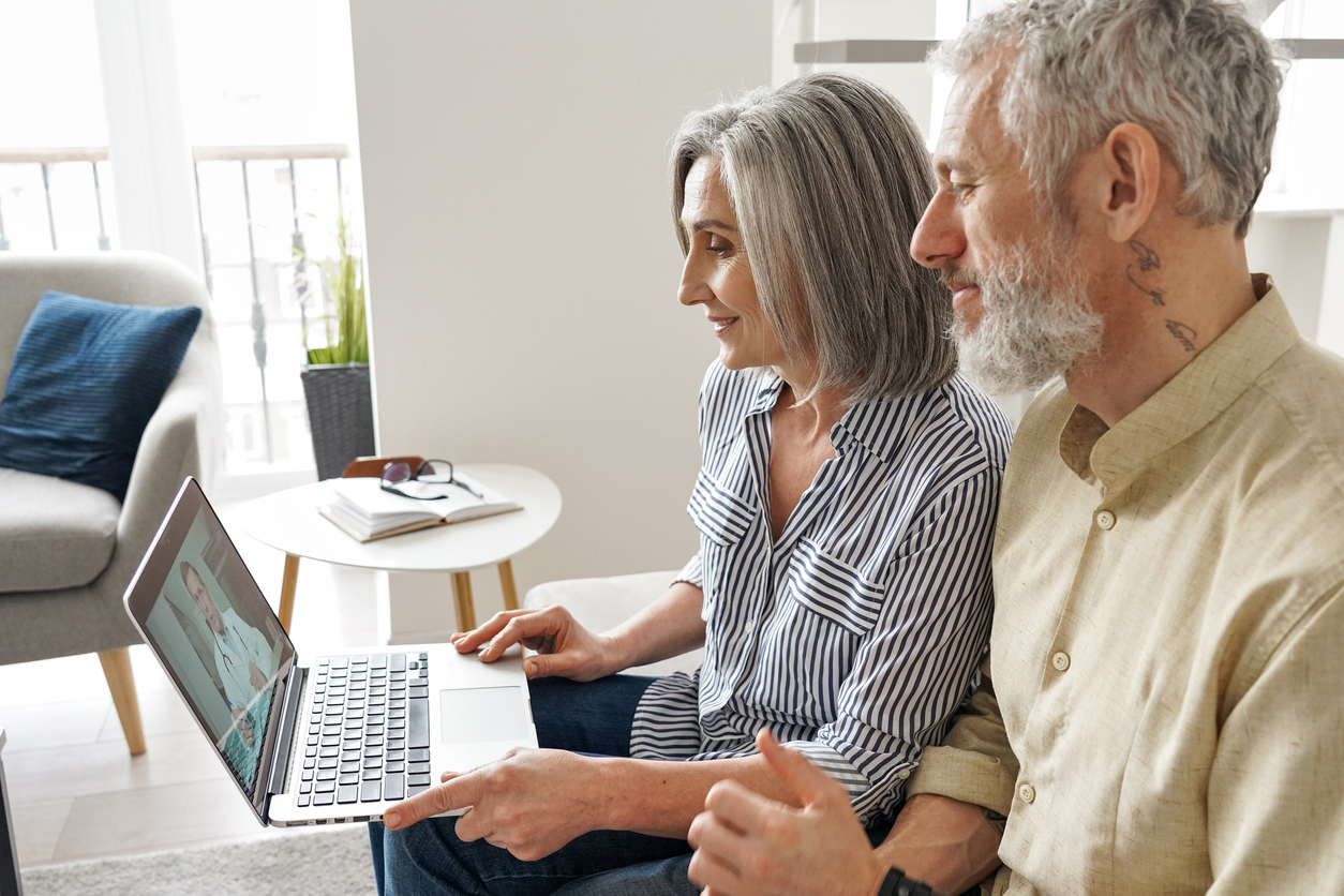 Couple using a laptop to access telehealth counseling