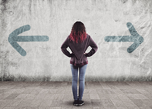 Teenage girl staring at a wall with arrows pointing left and right