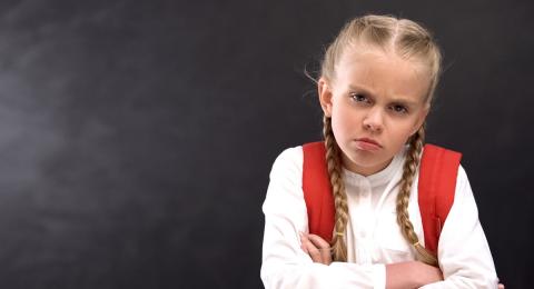 Child pouting with arms crossed