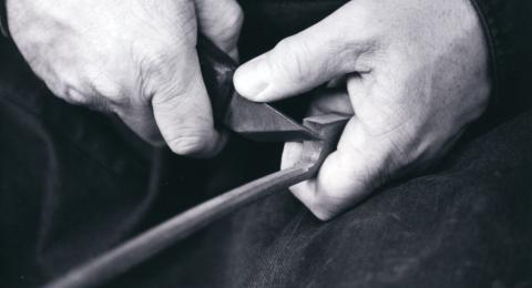 hands carving a violin bow