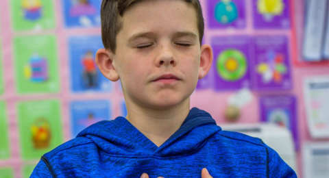 young boy sitting with closed eyes