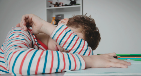 Child resting head on desk