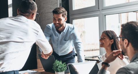 men shaking hands across table