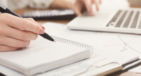 woman holding pen over notepad