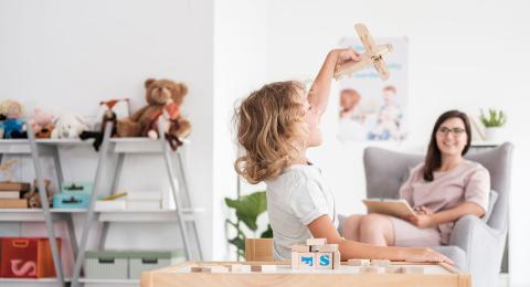 child playing with wooden airplane