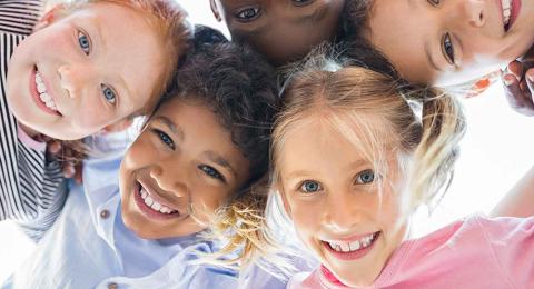 circle of children smiling over camera