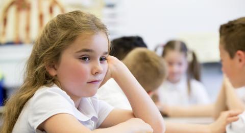 Child in classroom looking into distance