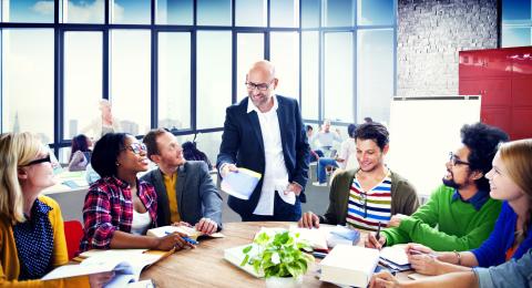 employees smiling at boss at a round table