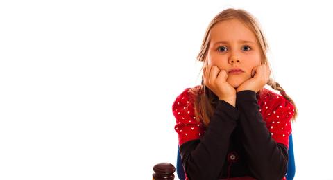 child sitting in front of gavel with head resting in hands