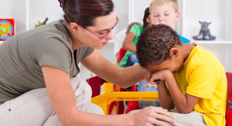 Teacher comforting a crying boy
