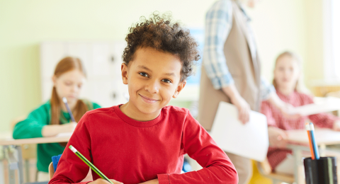 child sitting at desk writing