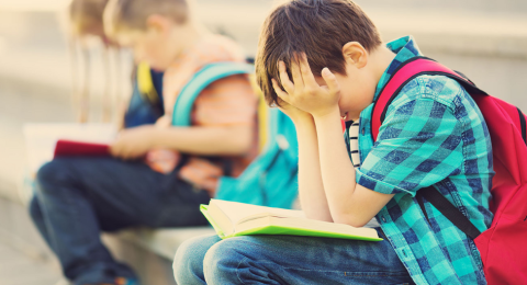 children with backpack sitting on stairs