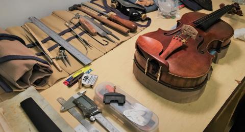 violin on a workbench with tools