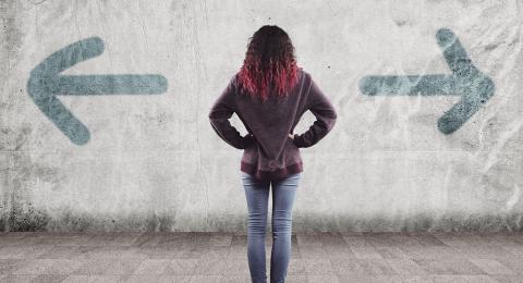 girl standing between 2 arrows facing opposite directions