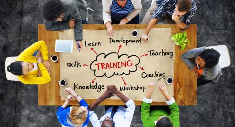 Overhead view of people around a table that has a training diagram on it
