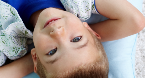 relaxed boy with arms behind head