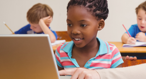 Teacher teaching pupil to use computer
