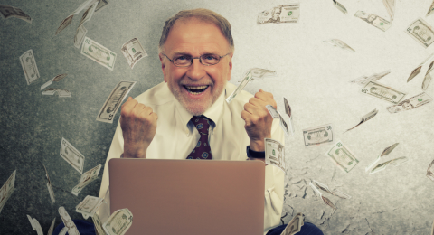 Man writing grant surrounded by money