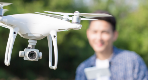 person blurred in background flying white drone