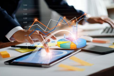 Digital Illustration of businessperson's hands using an ipad with charts and graphs overlaid