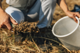 person adding soil to a bucket