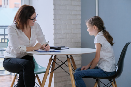 An adult and child sitting at a small round table