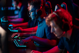 People in a neon-lit room on laptops