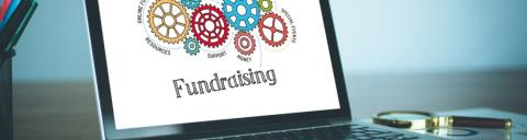 laptop showing a fundraising graphic with gears