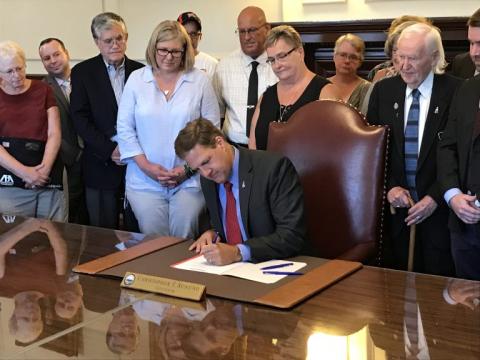 Governor Sununu signing a bill into law