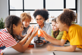 A teacher and young students examining scientific equipment