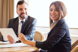 Two smiling businesspeople at a table