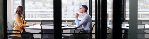 Two businesspeople meeting at a table on a balcony