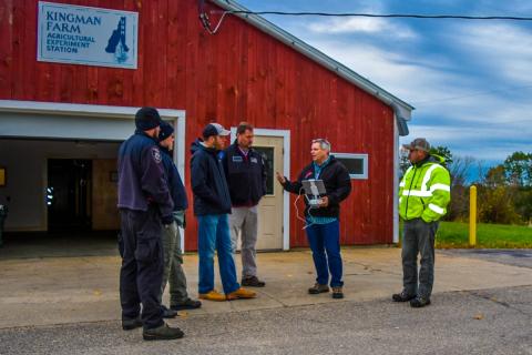 Group of people talking in front of barn