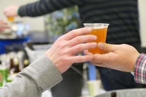 Person handing beer to someone else