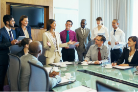 business woman standing at head of table talking