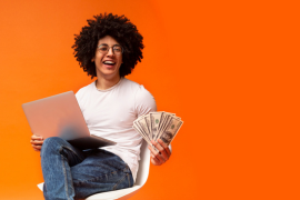 happy person holding laptop and money