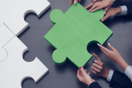green puzzle piece with hands assembling