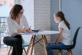 adult and youth sitting at table talking